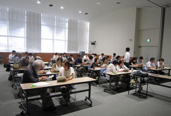 長机に2名ずつ座り声掛けの練習をしている参加者の人たちの写真
