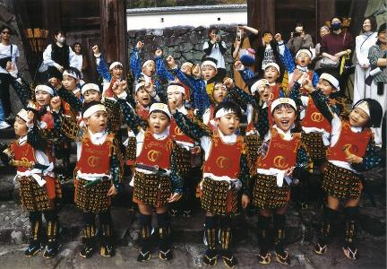 子どもたちが武者姿で埋見門の前で掛け声を掛けている様子を写した作品