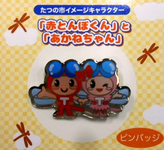 手をつないだ赤とんぼくんとあかねちゃんのピンバッジの写真