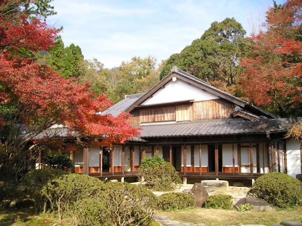 所々紅葉した木々に囲まれた、立派な庭のある御涼所の写真