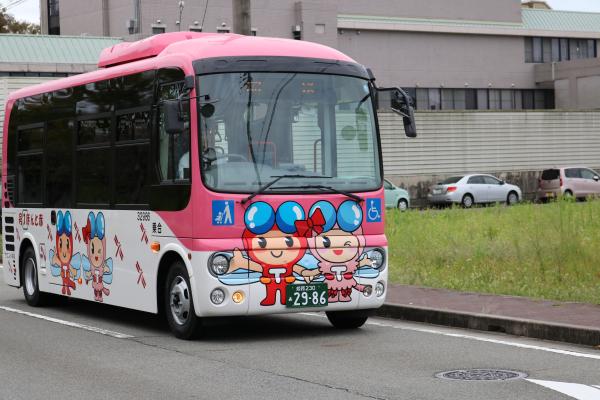 道路を走るコミュニティバスを斜め前から撮影した写真