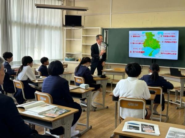 生徒たちが黒板に映し出された地図をみて説明を聞いている写真