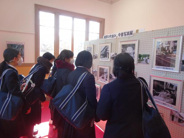 制服姿の学生がバックを持ったままミュージアムの展示品を見ている写真