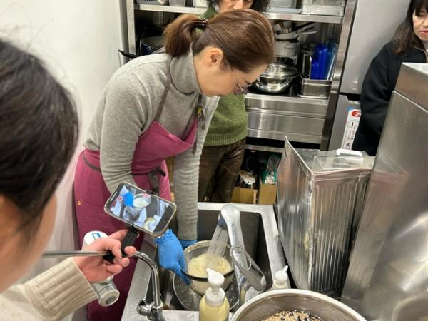 女性がゆでた素麺を水洗いしている様子を写した写真
