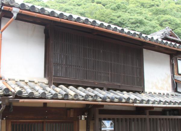 2階建ての窓の外に茶色の木の柵に格子が設置された木製出格子の写真