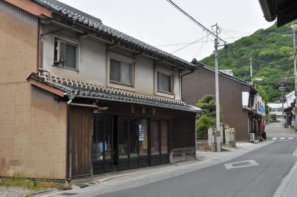 奥の山あいまで続く道路の左側に古い木造の家が立ち並んでいる龍野城下町の写真