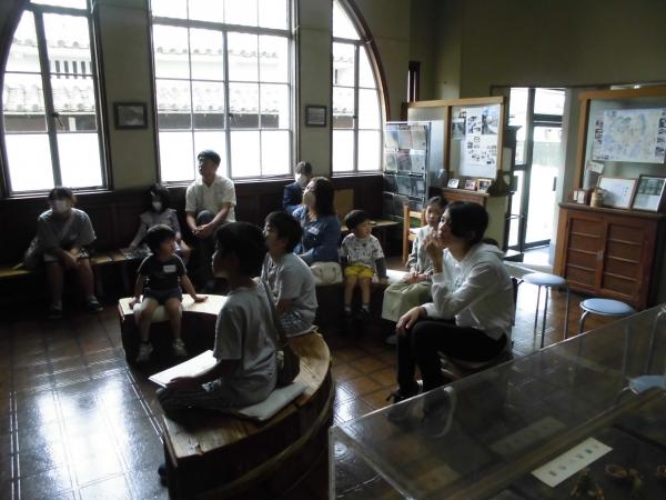 醤油資料館で椅子に座りビデオを見ている参加者11名をメインに写した写真
