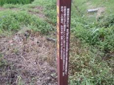 白色でなんらかの説明が書かれている赤色の四角い棒の看板のようなものを写した写真