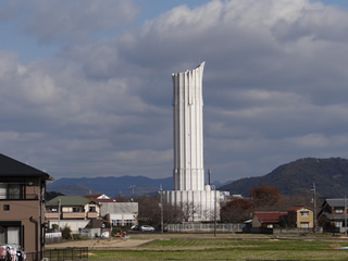 上部が斜めに切り取られた様な形をした白い外壁の野田配水塔の写真