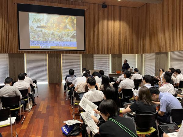 前方のスクリーンに映しだされた映像を参加している方々が見ている様子を後ろから写した写真