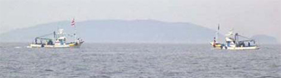 沖合に止まる2艘の船の写真