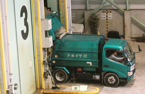 集めてきたゴミを収集車の後ろからピット内に降ろしている写真