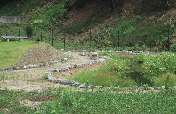 広い敷地の中の中央にため池のような使った水をためている場所が設置されている写真