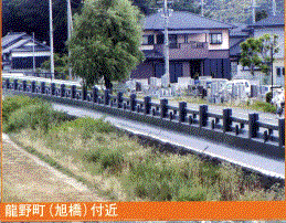 住宅が建つ手前にかかる畳堤が設置された旭橋の写真