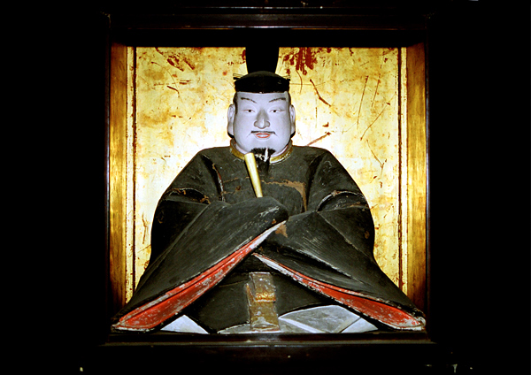 金色の屏風の前に鎮座する天満神社の菅原道真像を正面から撮影した写真