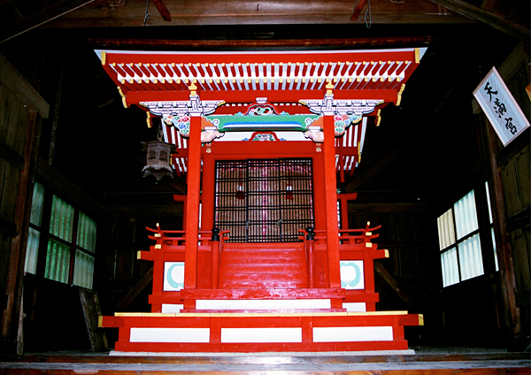 朱色の天満神社の本殿を正面から写した写真