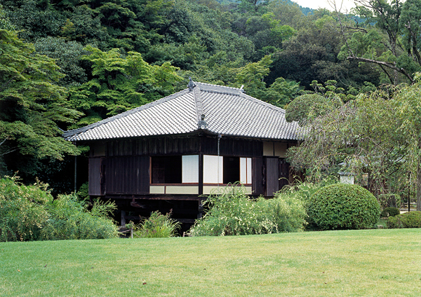 公園内の緑いっぱいの山や木に囲まれた聚遠亭を撮影した写真