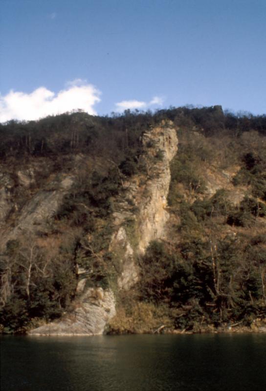川の向こうにある山の一部の白く大きな屏風岩を撮影した写真