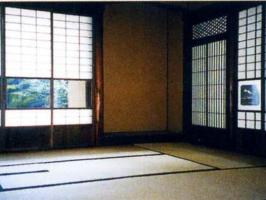 ふすまの途中がガラス張りになり外の風景が見える茶室内の写真
