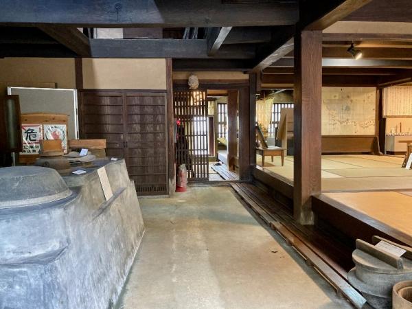 左側に窯があり右側には広い和室のなっている民俗館土間の写真