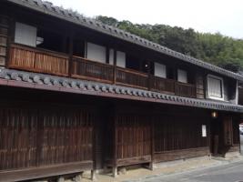 瓦屋根の木造和風造りの細長い2階建ての室津民俗館の外観写真