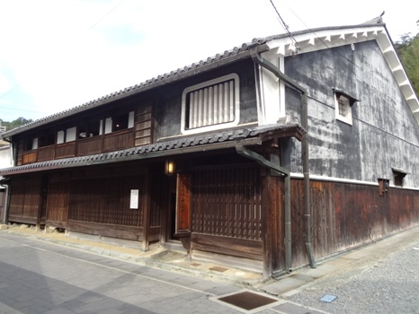 木造2階建ての細長い和風造りの家の2階の大きな窓が白の格子で虫籠窓になっている室津民俗館の外観写真