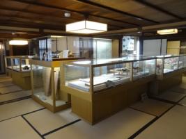 畳の部屋に資料が入ったガラスケースがたくさん置かれている展示室の写真