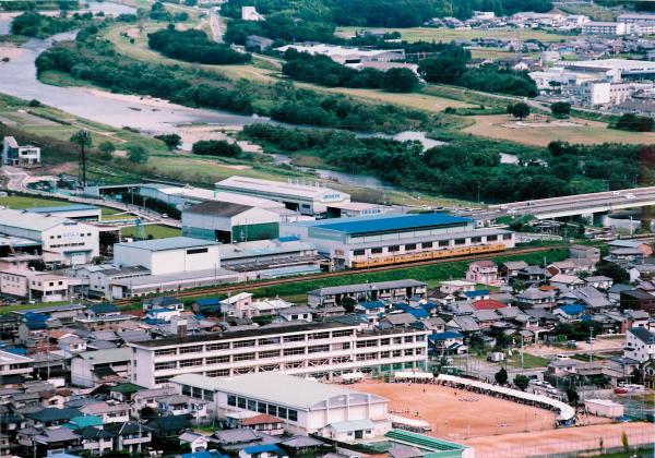 上空から駅を中心として学校や川などの街の全体を撮影した写真