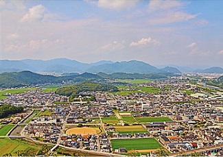 所々に畑や木々の生えた山のある竜野市の市街地をはるか上空から撮影した写真