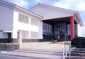 白い外壁でガラス張りの入口がある大きな御津図書館の建物を写した写真