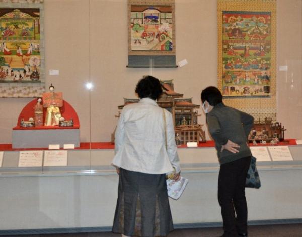 2人の女性が展示された3点の雛人形を見ている写真