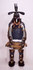 紺色を基調とした鎧に黒色の兜、黒に金色で装飾が描かれた臑当の伊予札縹糸下散紅威胴丸具足の写真