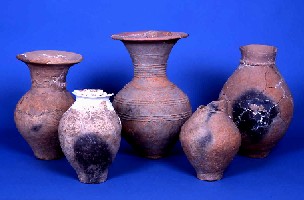 土色の壺のような大きな土器が3点横に並べられその前に小さな土器が2点並べられた写真