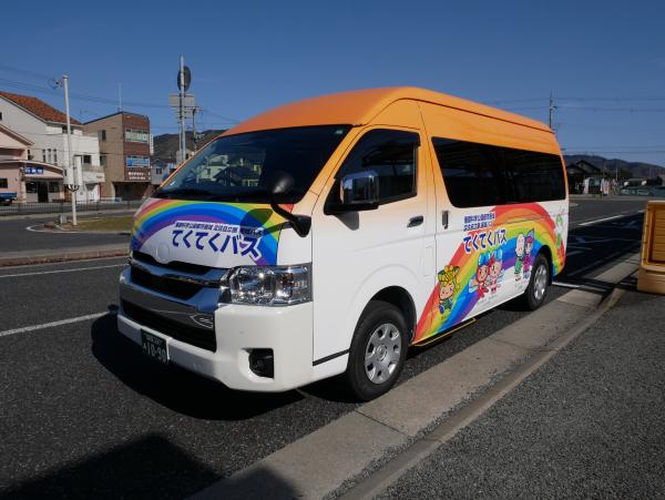 車体の上半分がオレンジ色のてくてくバスを右前方から写した写真