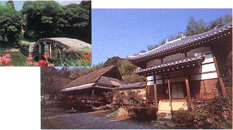 石を積み上げて作られたアーチ橋と、茅葺屋根と瓦屋根の建物が並んで建っている写真