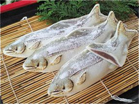 巻きすに置かれ、中に餡が入っている3匹の魚の形のお菓子の写真
