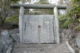 石段の頂上に石造りの鳥居と門が立っている野見宿禰神社入り口の写真