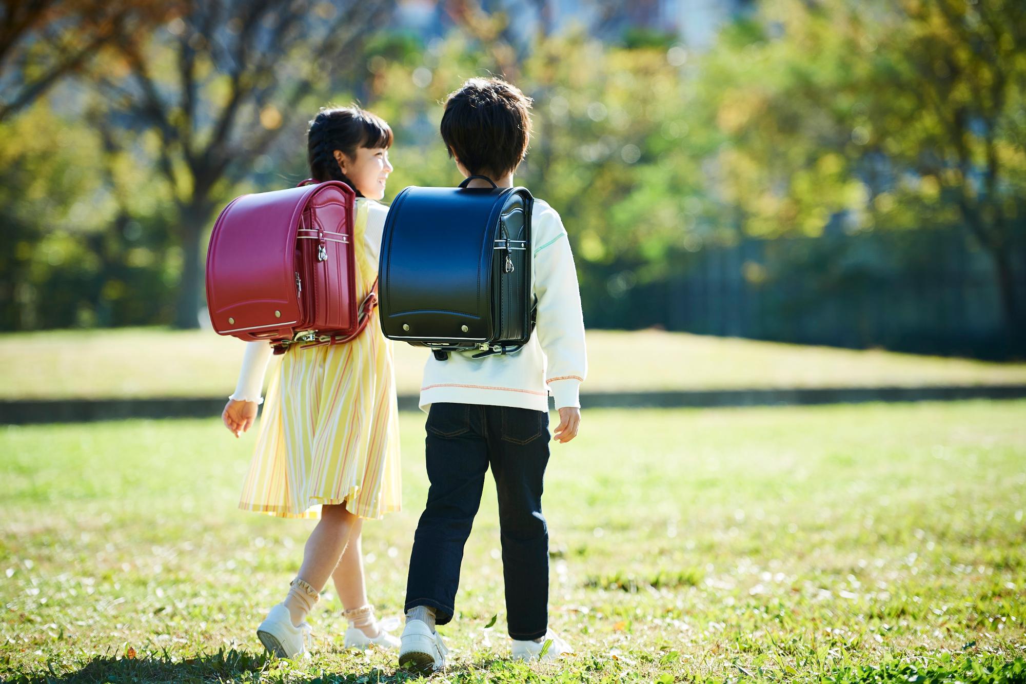 ランドセルを背負った男の子と女の子が歩いている様子