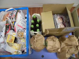 白い机の上に並べられた、お菓子や缶詰、調味料などの2月に回収した食品の写真