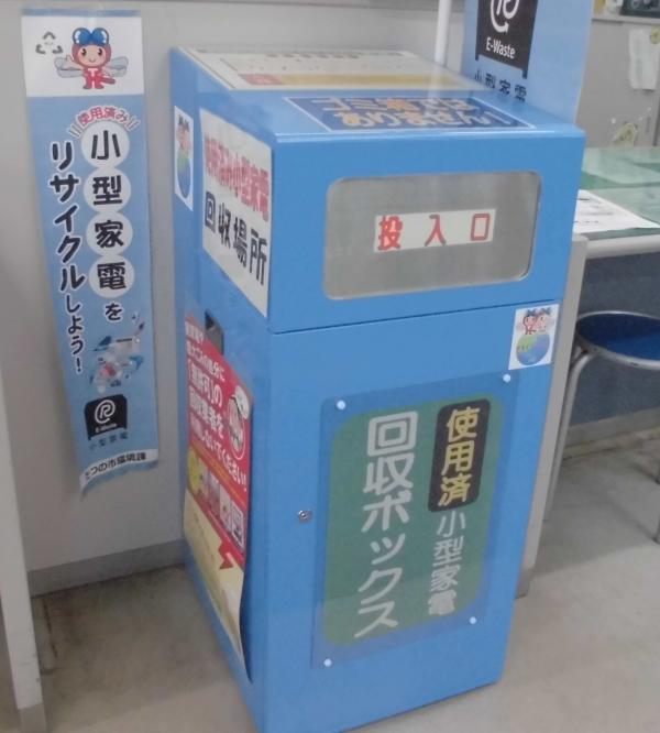 室内の受付窓口横に置かれた青色の回収ボックスの写真