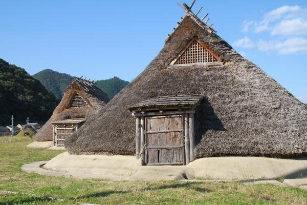 茅葺屋根の住居が立っている写真