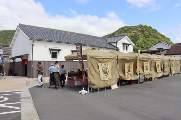 朝市開催場所の駐車場に横並びに設置されたたくさんの朝市のテントを、後方から写した写真