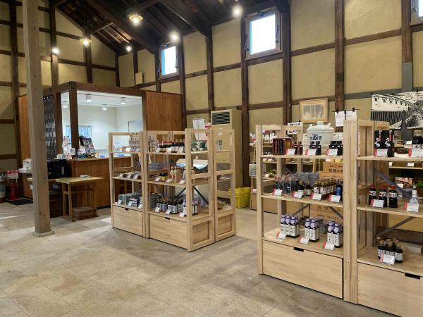 様々な瓶入りの商品が陳列された、蔵あかねの建物内にある販売スペースを写した写真