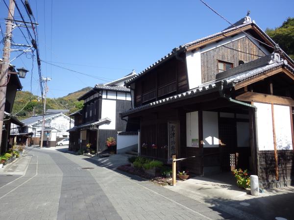 木造2階建ての家が道路に沿って建っている写真