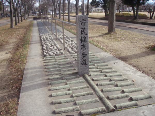 市民健康歩道と書かれた石碑の立っている、様々な形をした石が設置してある歩道の写真