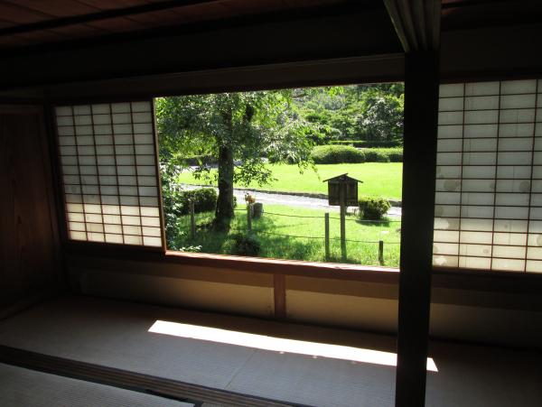 両開きの障子の窓から外の緑の景色が見える畳の聚遠亭の茶室の写真