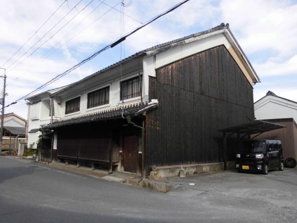 外壁が黒っぽい2階建ての建物の写真