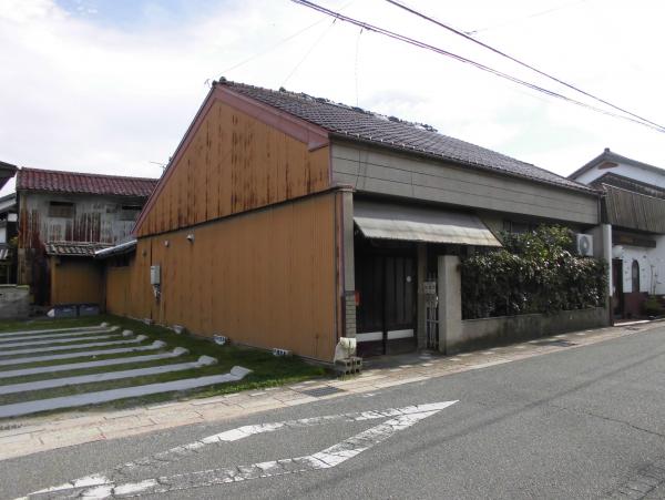 茶色の屋根瓦に庇付の入り口を写した外観写真