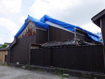 令和6年度修理物件1号（修理前）ブルーシート養生され外壁もトタン張りになっている