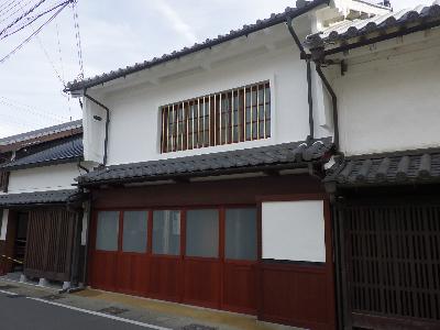 令和6年度修理物件2号（修理後）瓦葺きの下屋根、木製片引き戸、真鍮格子を持つ姿に修理されている